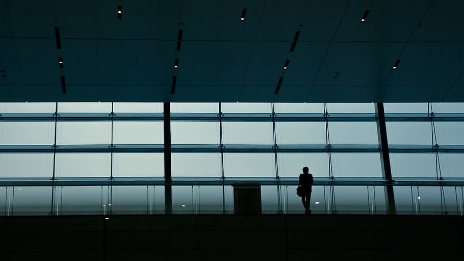 silhouette photography of person standing behind glass wall, man standing near glass wall