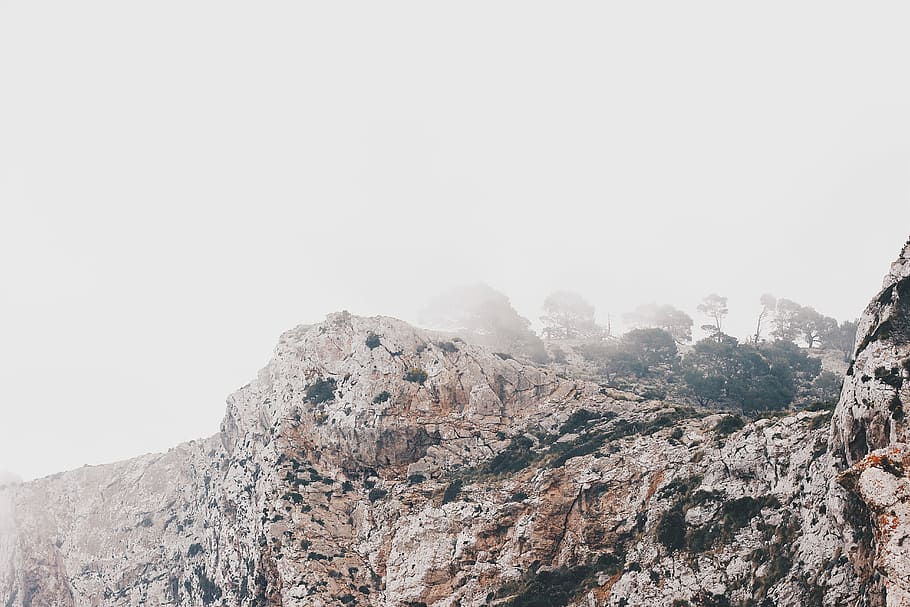 shallow focus photography of white rocky mountain, mountain covered with fog HD wallpaper