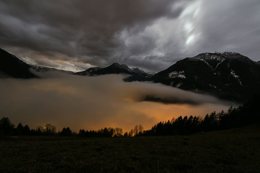 landscape photo of mountain surrounded by clouds under cloudysky, silhouette of trees and mountain cover by clouds HD wallpaper