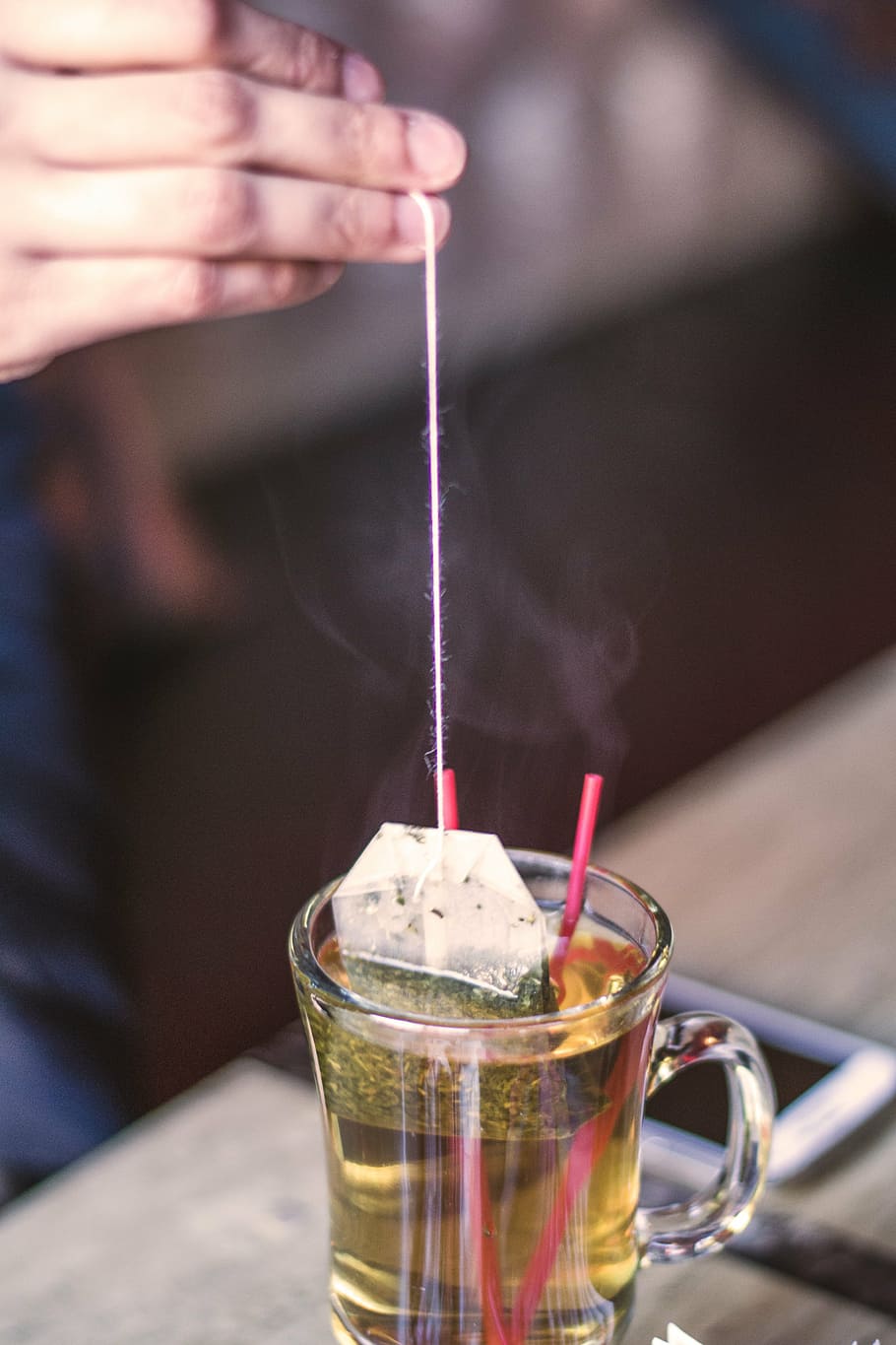 tea pack in clear glass mug, person, dipping, bag, arabic, straws HD wallpaper