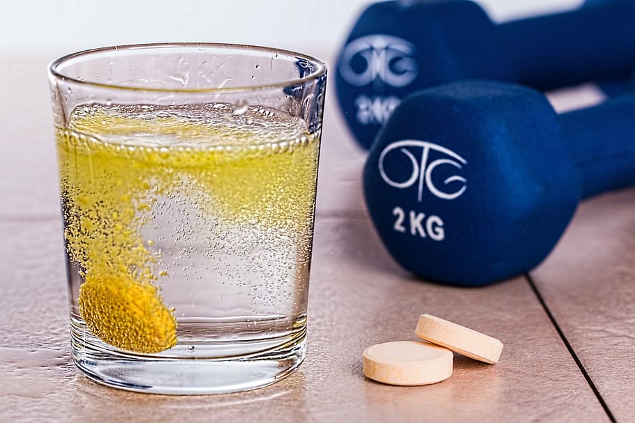 clear rock glass beside two white medication tablets near pair of 2 kg blue fixed dumbbells, HD wallpaper
