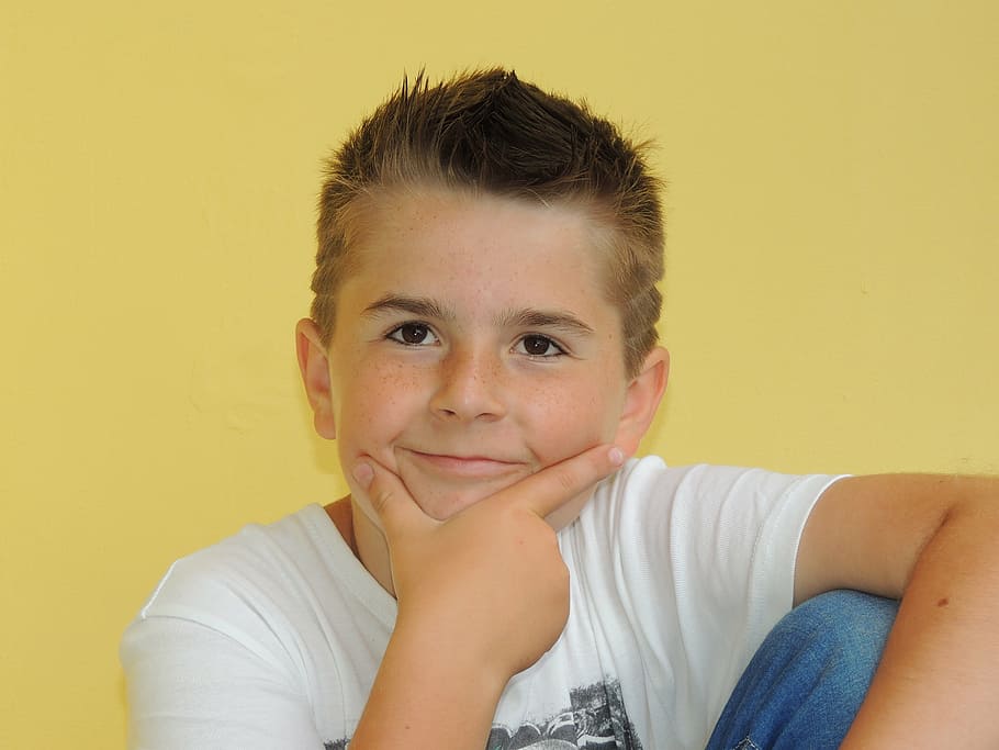 boy sitting near yellow wall doing hand gesture, young, face HD wallpaper