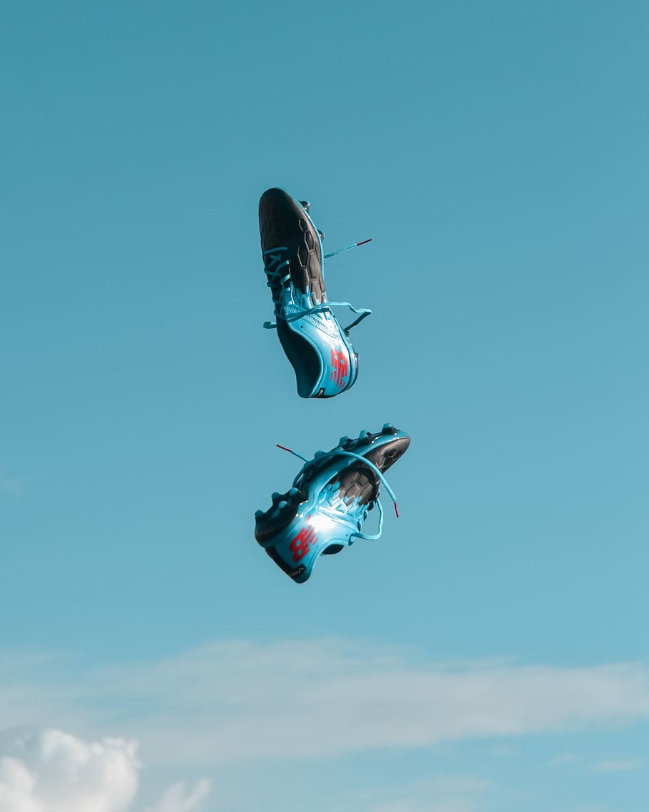 pair of blue-and-black New Balance cleats in the air under teal sky with white clouds, pair of black-and-blue New Balance cleats in air, HD wallpaper