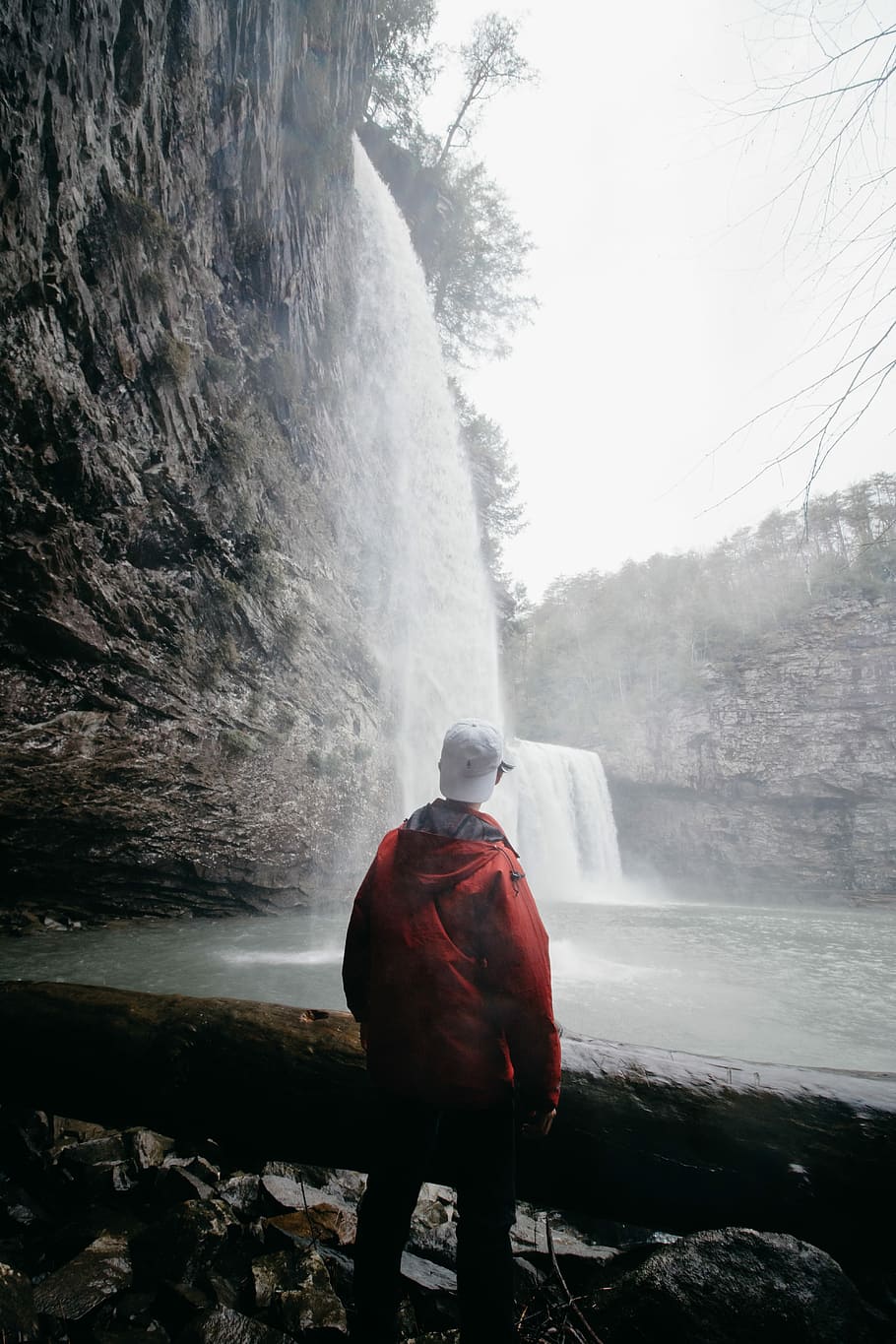 man standing in front of waterfalls, man standing on rock facing waterfall HD wallpaper