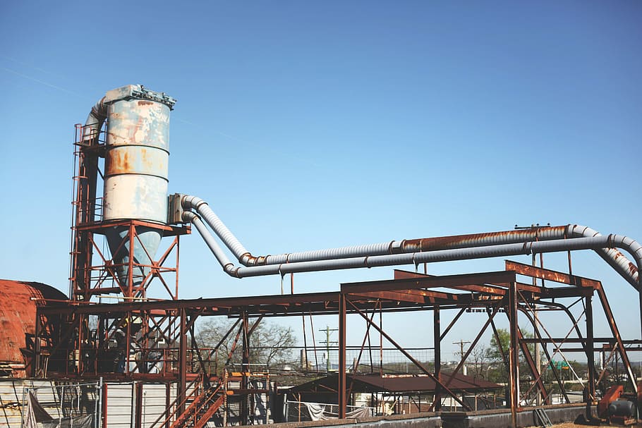 white industrial tank on top of platform under clear sky, plant