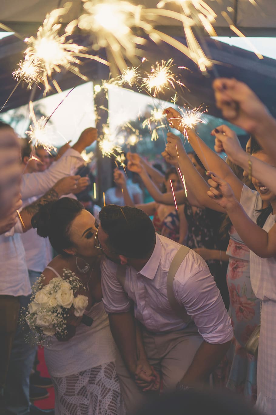 newly wed kissing surrounded by people, wedding couple kissing between people holding sparklers HD wallpaper