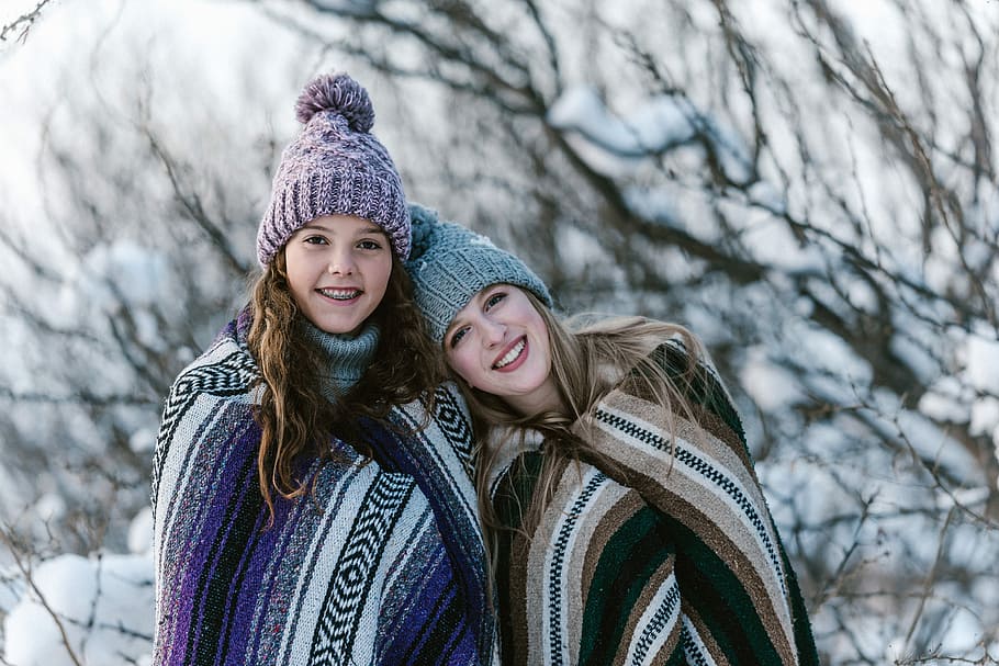 two person wearing beanie during daytime, girl and woman wearing knit caps and assorted-color blankets near bare trees covered with snow during daytime, HD wallpaper