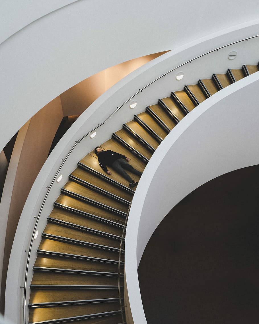 man laying on staircase, man laying on spiral staircase, person HD wallpaper