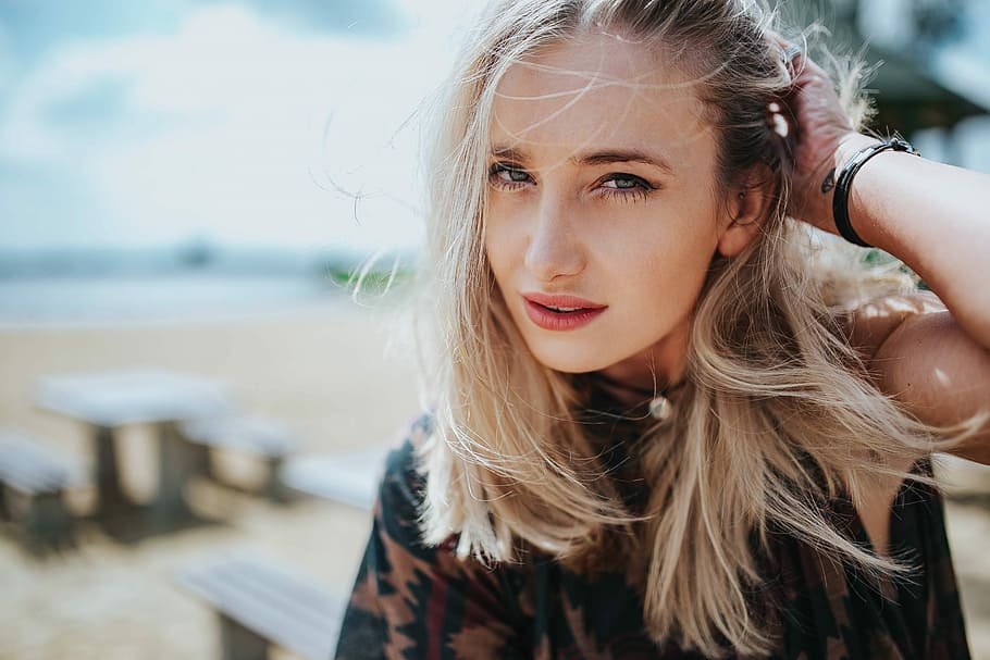 Beautiful blonde woman relaxing with a can of coke on a tree stump by the beach, HD wallpaper