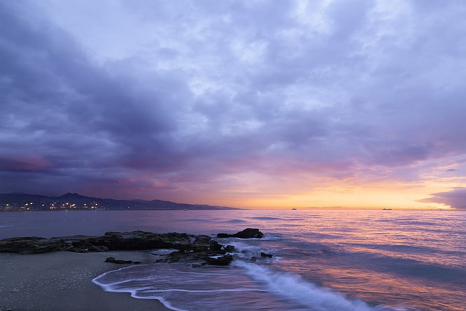 waves of body of water splashing on sand, time lapse photography of white sand beach under golden hour HD wallpaper