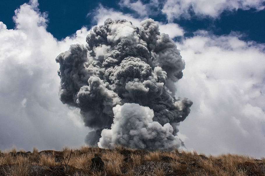 black smoke burst in brown open field at daytime, grey smoke above brown hill during daytime HD wallpaper