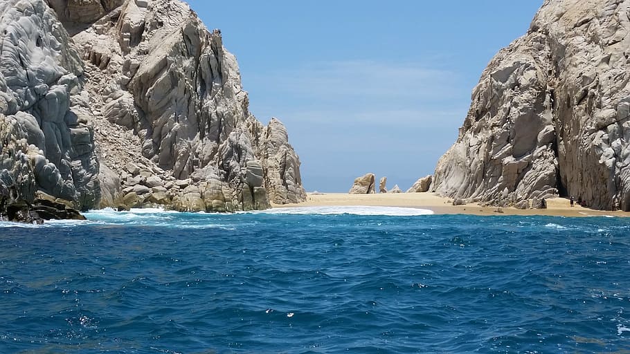 rock formation on body of water during daytime, beach, island
