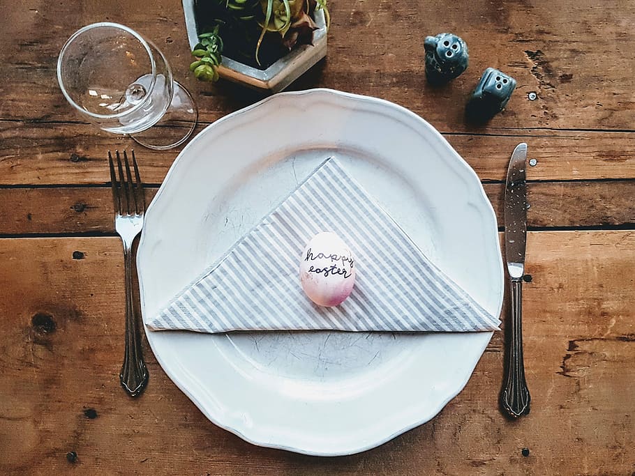 white egg on white ceramic plate between fork and bread knife on brown wooden panel HD wallpaper