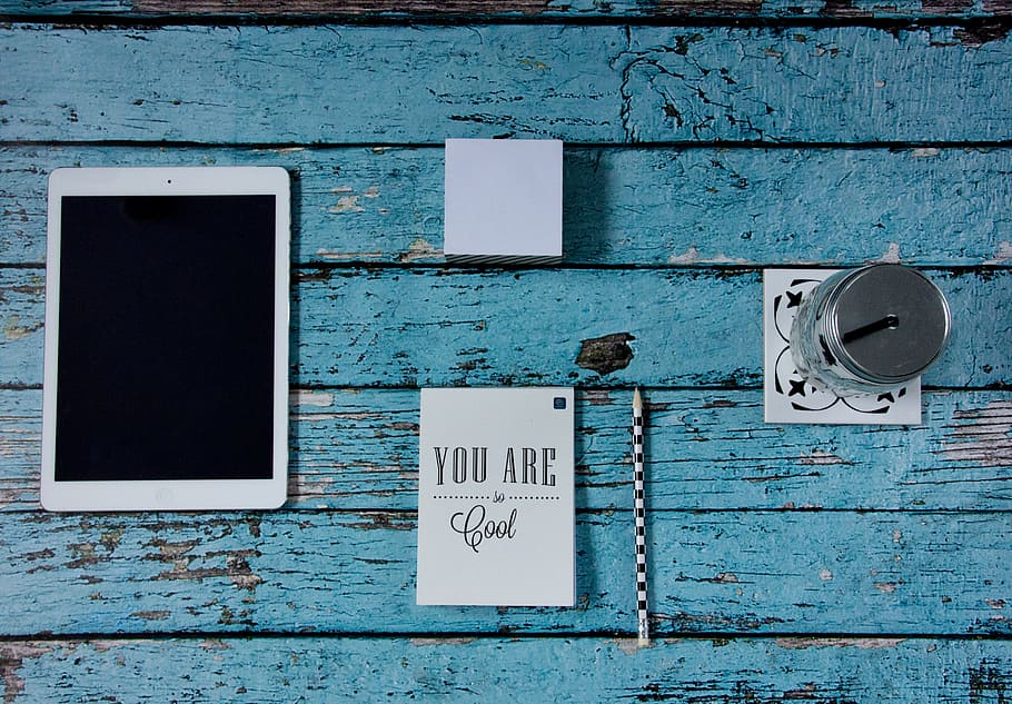 iPad beside notebook, pencil, sticky note pad, and mason jar HD wallpaper