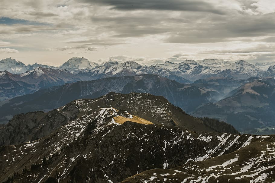 aerial photography of mountains under cloudy sky, black mountain covered with snow HD wallpaper