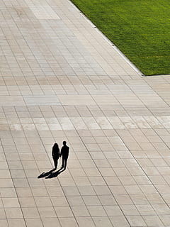 couple waking on concrete street, silhouette of man and woman holding hands while walking HD wallpaper