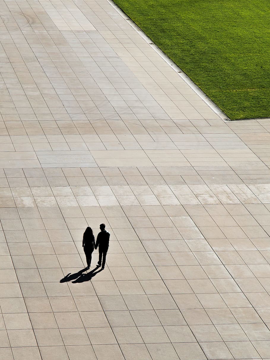 couple waking on concrete street, silhouette of man and woman holding hands while walking HD wallpaper