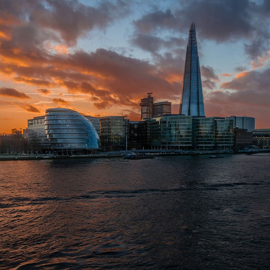 landscape photography of a city, cityscape near body of water at sunset HD wallpaper