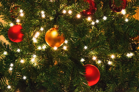 turned-on string lights on Christmas tree beside baubles, red HD wallpaper