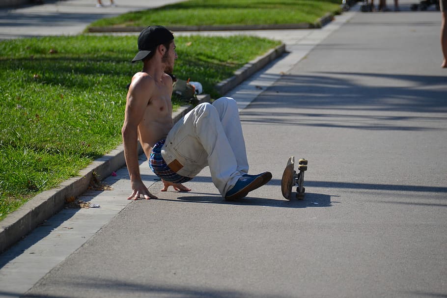 man using skateboard beside green grasses during daytime, man falls down on skateboard HD wallpaper