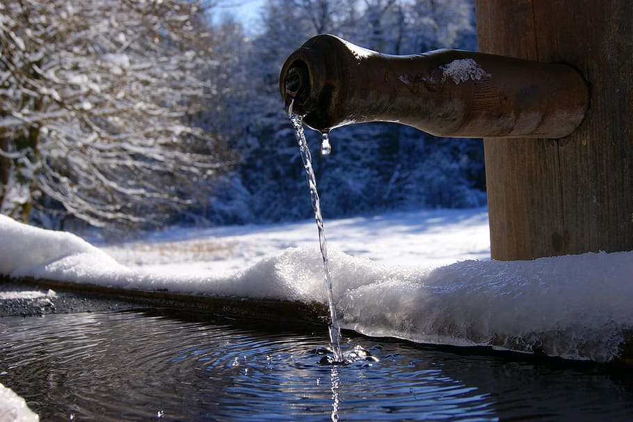 brown bamboo faucet dropping water near trees covered with snow at winter HD wallpaper