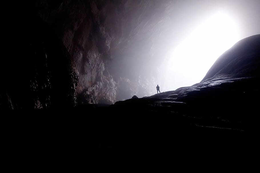 person inside of cave, silhouette of person in cave, mist, fog