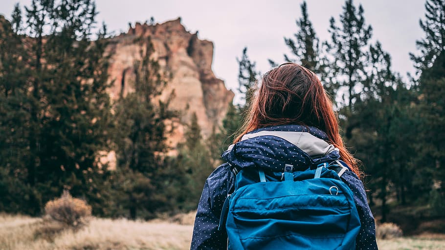 woman wearing blue jacket and blue backpack during daytime, woman wearing blue backpack in front of mountain HD wallpaper
