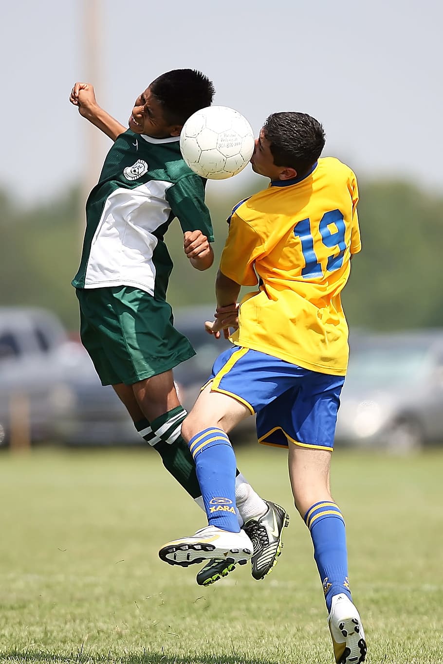 two soccer players heading a soccer ball in field, Football, Conflict