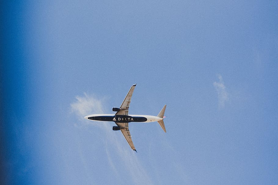 low angle photography of white and black airplane under blue sky at daytime