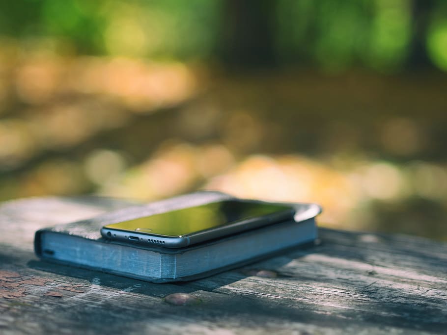 selective focus photography of post-2016 iPhone on book, bible HD wallpaper