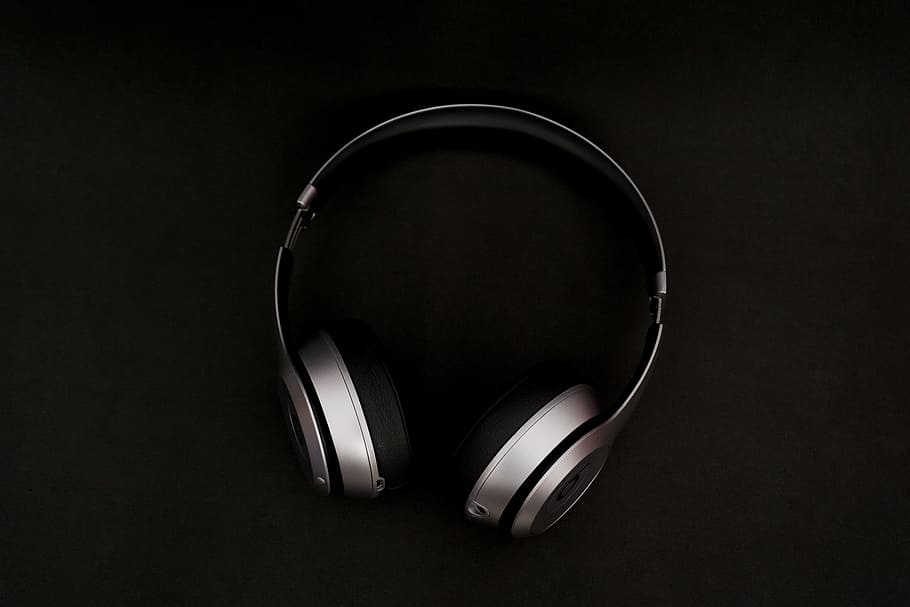 silver headphones on top of black surface, silver beats by dr. dre wireless headphones
