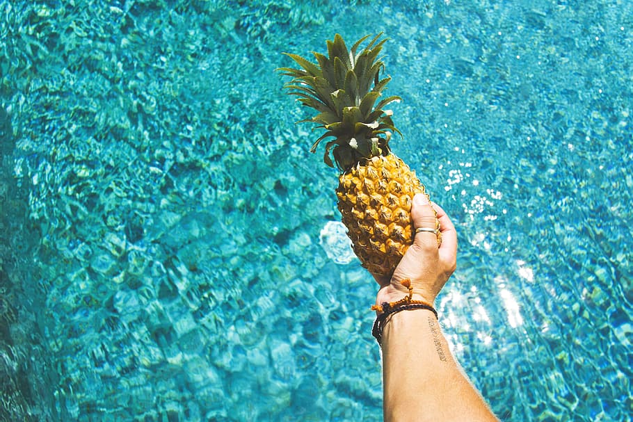 A man holding pineapple fruit over water, food/Drink, healthy, HD wallpaper