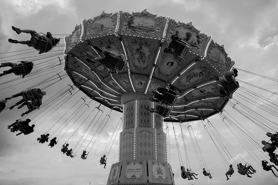 people on amusement park riding on ride, worm's eye view of people riding on amusement ride