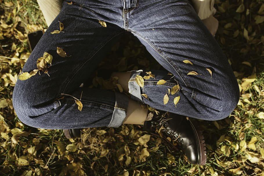 sitting man in blue jeans, person sitting on ground on leaves HD wallpaper
