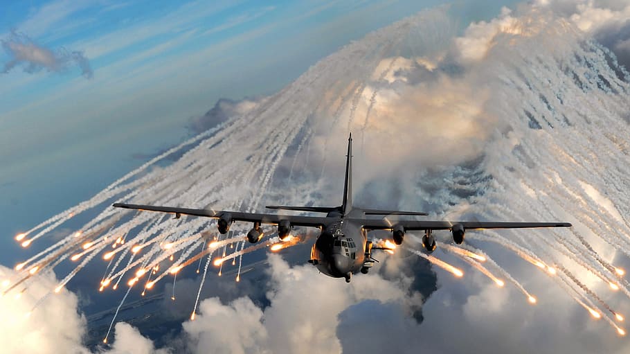 black plane above white clouds, military aircraft, flares, drop