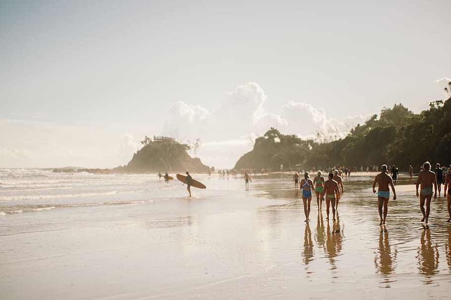 people walking along beach during daytime, people gathered in a beach shore with rock formations HD wallpaper