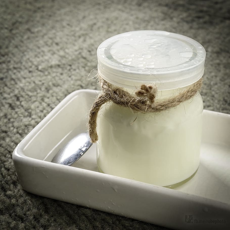 closed plastic mason jar near gray spoon, milk, yogurt, vitamins