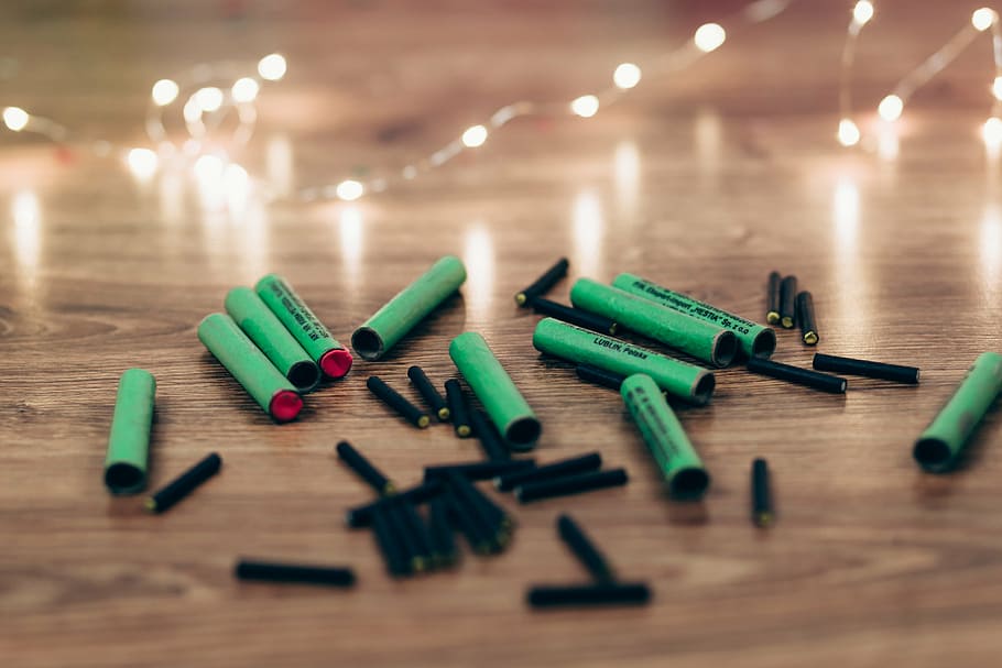 closeup photo black and green firecrackers on brown wooden surface HD wallpaper