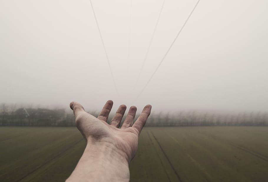 Reaching into empty field, person standing on green field with misty weather HD wallpaper