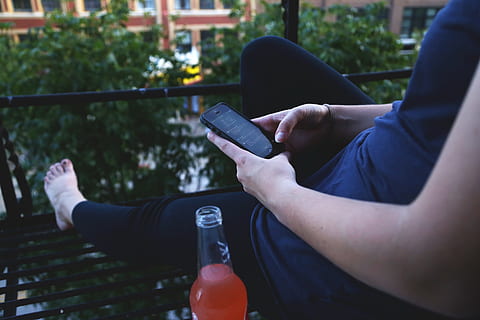person holding black iPhone 5 sitting beside glass bottle, smartphone HD wallpaper