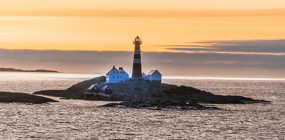 photography of brown lighthouse near island at daytime, norway island