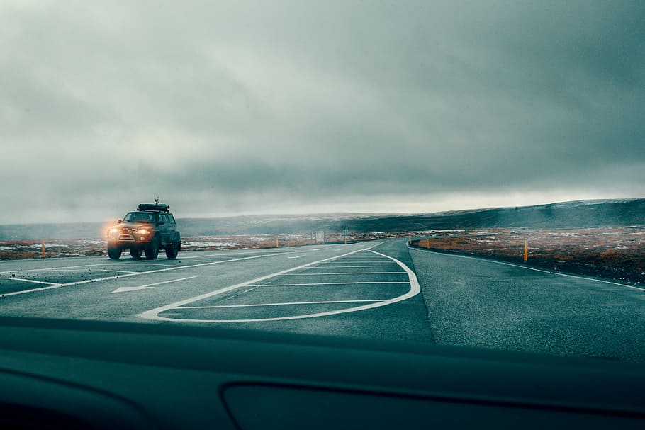 gray vehicle on roadway during daytime, black off-road car cruising on free way