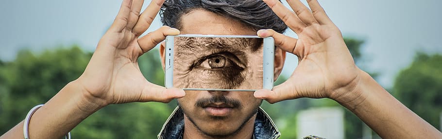 person holding white Android smartphone displaying eye, cyclops HD wallpaper