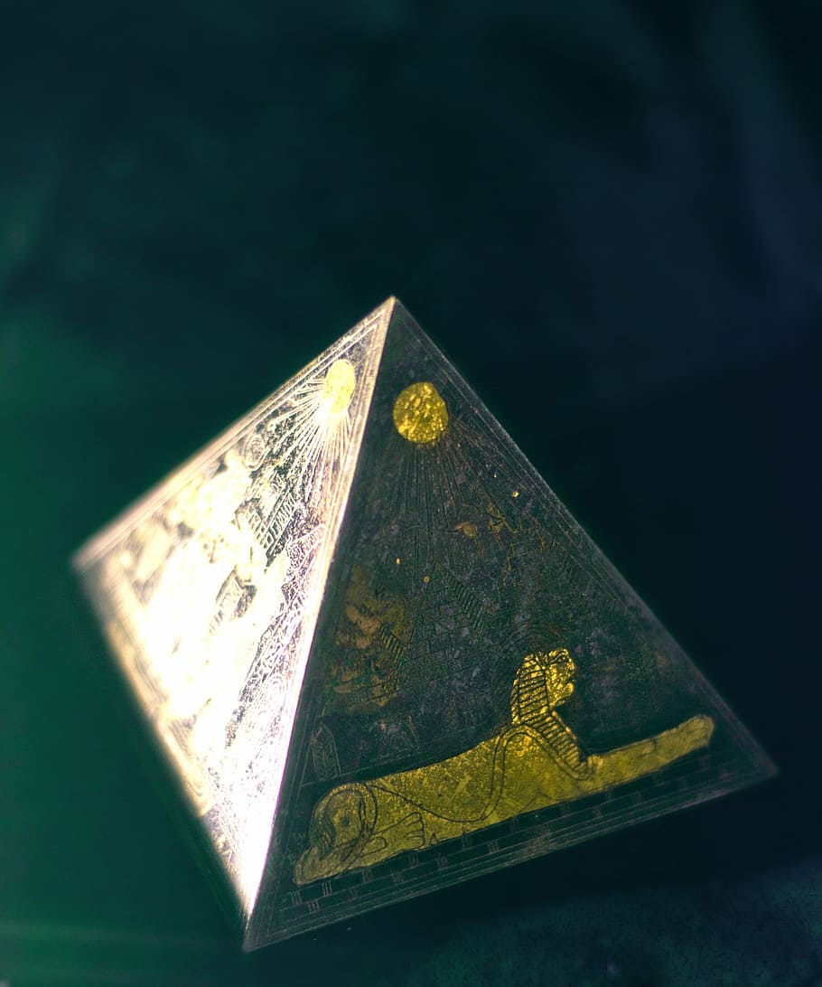 Pyramid miniature placed on black surface, egyptian, mysterious