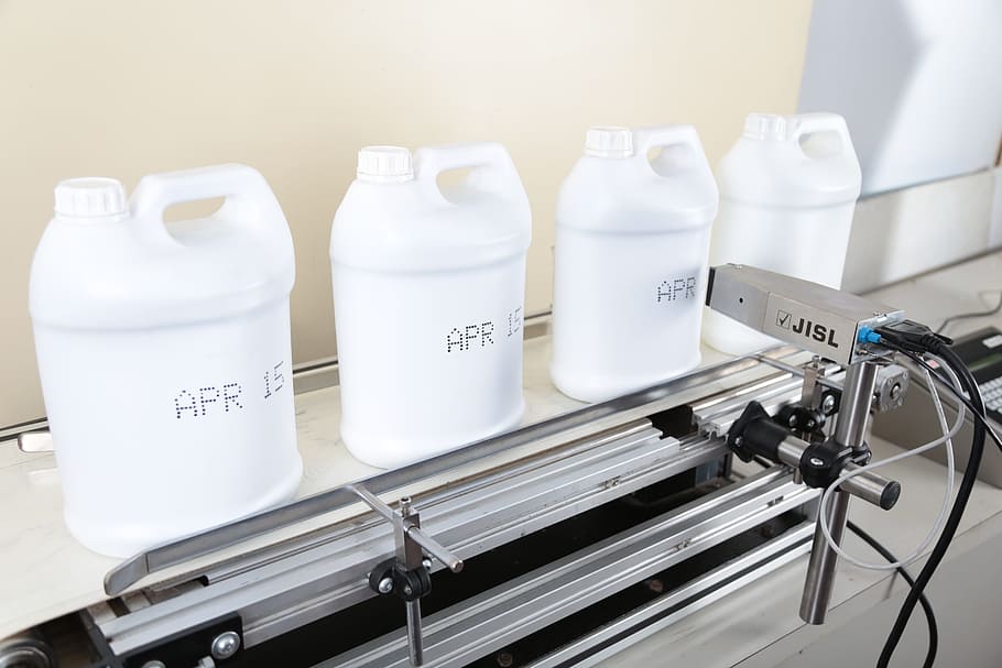 four white plastic bottles on gray stainless steel machine HD wallpaper