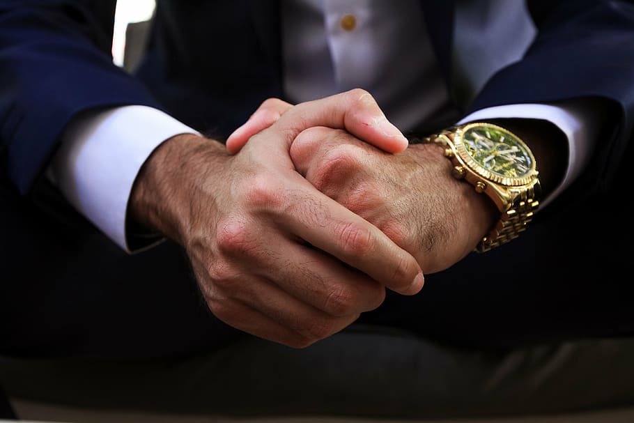 person wearing round gold-colored skeleton watch with gold-colored band HD wallpaper