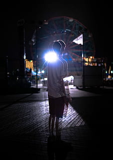 photo of man standing on street, boy standing in front of ferris wheel at night time HD wallpaper