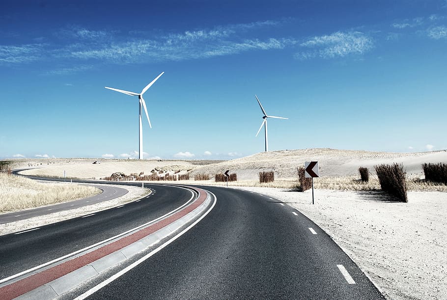 two windmills, two white windmills near gray concrete road under blue sky HD wallpaper