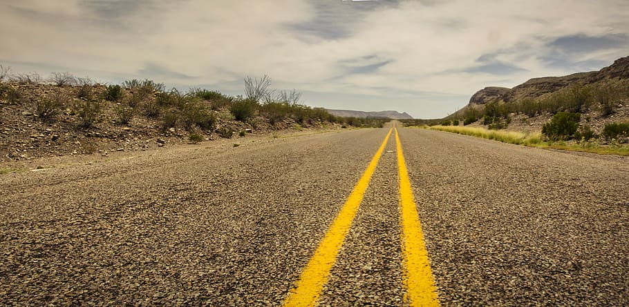 concrete road beside rock hill under cloudy sky at daytime HD wallpaper