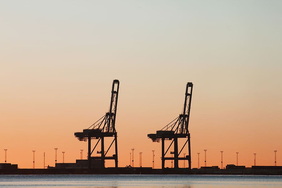 two black oil platforms, silhouette of buildings during dusk HD wallpaper
